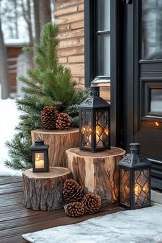 three wooden logs with pine cones and lights on them sitting in front of a door