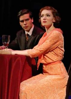 two people sitting at a table with wine glasses