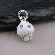 "This Vanilla Cupcake Charm is 3-dimensional and comes with a silver jump-ring as pictured. Please note that photo is not to scale and may appear larger to show detail. Refer to exact measurements below. Additional attachments (lobster clasp, large-hole bead, necklace chains) are available from the charm-attachments drop-down menu.  For a visual example of the different attachments and what each one is best suited for, scroll through the photos until you see the example photo or visit https://etsy.me/2BY7DAW for detailed information.    { DETAILS } ★ Material: Pewter, Enamel, Crystal Sprinkles ★ Finish Color: Silver  ★ Measurements: 1/4\" x 1/2\" ★ Dimensions: 3-Dimensional { SIMILAR ITEMS }  More cupcake and dessert  themed items available from my shop: https://www.etsy.com/shop/treasured White Pendant Charms For Gifts, White Pendant Charms For Gift, Sweet Silver Handmade Jewelry, Sweet Handmade Silver Jewelry, Novelty White Sterling Silver Jewelry, White Sterling Silver Novelty Jewelry, White Novelty Jewelry With Charms, White Round Pendant Charms For Gifts, Nickel Free White Charms For Gifts