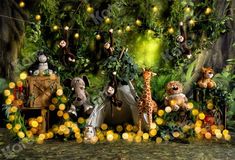 there are many stuffed animals in the jungle with lights strung from it's sides