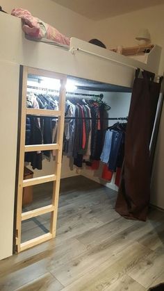 there is a loft bed with a ladder in the closet and clothes hanging on racks