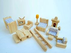 wooden toys are arranged on a white surface with one toy bed and the other furniture