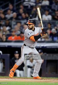 a baseball player holding a bat on top of a field in front of a crowd