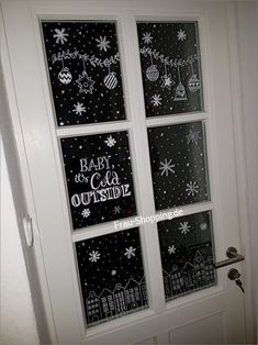 the door is decorated with black and white snowflakes, christmas decorations, and words