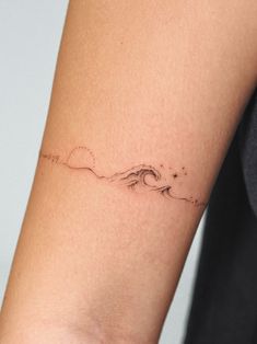 a woman's arm with a small wave tattoo on the left side of her arm