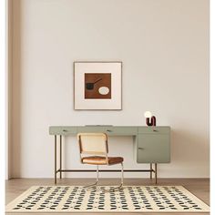 a room with a rug, chair and painting on the wall next to a desk