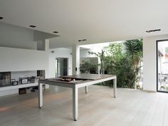 a white table and bench in a room with large glass doors leading to the outside