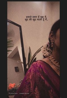 a woman in a sari looking at herself in the mirror with an inspirational quote on it