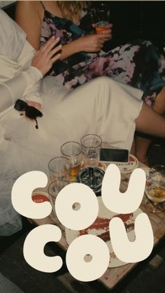 two people sitting on a couch with drinks in their hands and the words cou cou over them