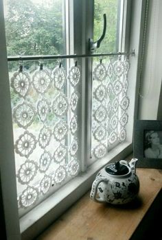 a white vase sitting on top of a window sill