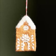 a gingerbread house ornament hanging from a string