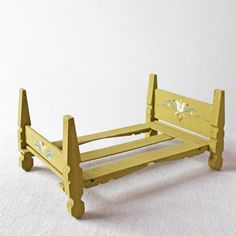 a small wooden bed frame sitting on top of a white surface