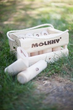 a wooden box filled with baseball bats sitting in the grass