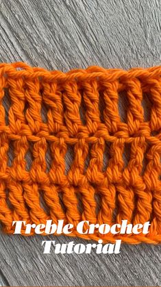 an orange crochet stitch on top of a wooden table