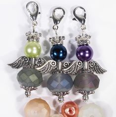 four different colored beads with angel wings on them