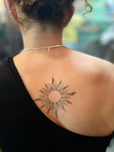 a woman with a sun tattoo on her back