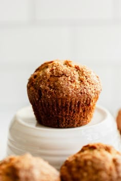 a muffin sitting on top of a white plate next to other muffins