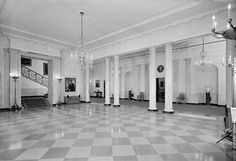 an empty room with columns and chandeliers in the center is seen in this black and white photo