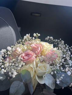 a bouquet of roses and baby's breath sits in the back seat of a car