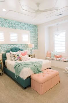 a bed room with a neatly made bed next to a window and a bench in front of it