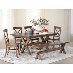 a dining room table and bench with flowers in vase on the top, next to an area rug