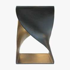 a black and gold sculpture sitting on top of a white wall