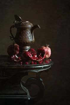 pomegranates and a teapot on a table