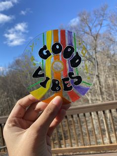 someone holding up a colorful cd with the words good vibes written in black on it