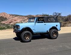 a light blue truck is parked on the side of the road