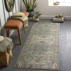 a large rug in the middle of a room with two benches and potted plants