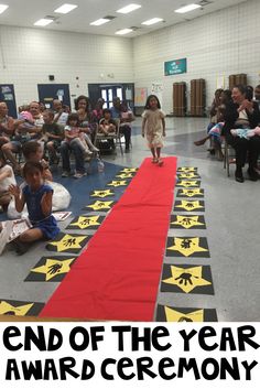 the end of the year award ceremony is being held in an auditorium with children sitting on chairs