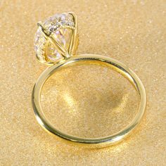 a yellow gold ring with two diamonds on it, sitting on a shiny surface in front of the camera