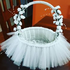 a white basket sitting on top of a wooden table