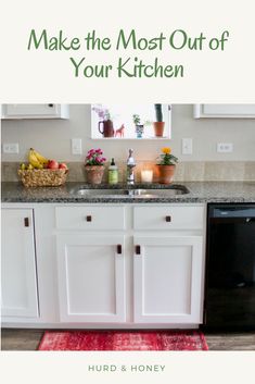 a kitchen with white cabinets and red rugs on the floor, next to a black dishwasher