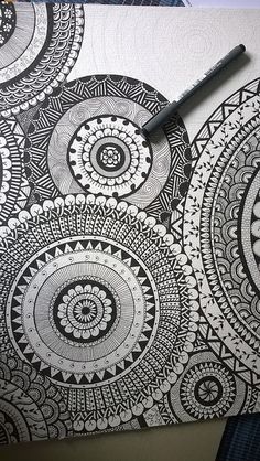 a pen is sitting on top of a piece of paper that has been drawn with black and white ink