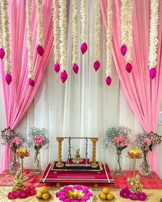 a decorated stage with pink drapes and flowers