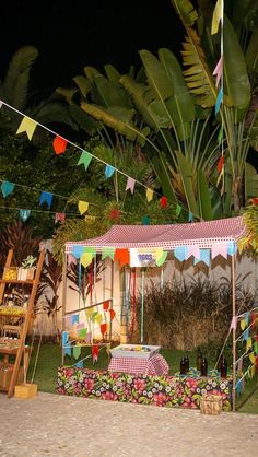 a small tent set up in the middle of a yard with flags and bunting