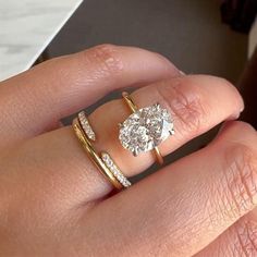 a woman's hand with two rings on top of her ring and the other one has