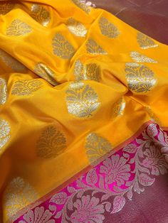 Beautiful Mango Yellow Banarasi Handloom Saree with Pink Border with Floral Patterns with Wide Border Cooper Zari used in Border and Pallu. Item : SareeColor : Mango Yellow and Pink Base Fabric : Banarasi Silk (Non-Pure) Blouse piece : Comes with Blouse pieceBlouse material : Banarasi Silk (Non-Pure) Fall & Edging: Comes with Fall and edging (Pico) and tassels attached Disclaimer -:- Color variation is possible due to various reasons like phone or desktop setting, resolution etc. Please don't ho Mango Yellow, Pink Color Combination, Pink Border, Banarasi Saree, Yellow And Pink, Banarasi Sarees, Handloom Saree, Floral Patterns, Blouse Piece