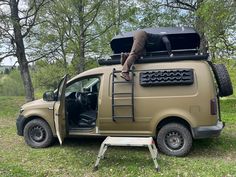 a man standing on the back of a brown van