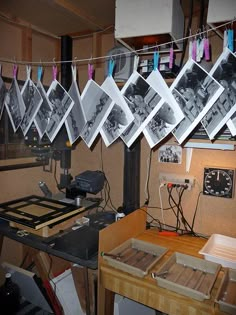 there are many pictures hanging on the clothes line