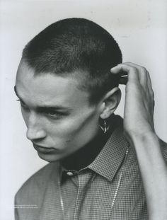 a black and white photo of a man with his hair styled in a high bun