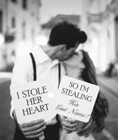 a couple kissing while holding signs that say i stole her heart