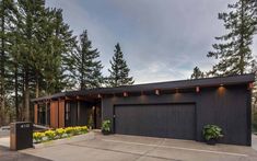 a black house with lots of trees in the background