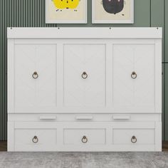 a white dresser with two pictures above it