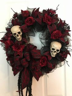 a wreath decorated with skulls and red roses