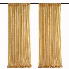 two gold curtains hanging on a white wall