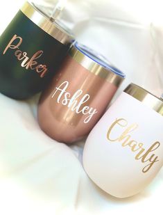 three personalized tumblers sitting on top of a white sheet with the words parker and ashley printed on them