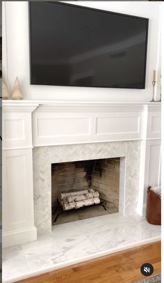 a white fireplace with a flat screen tv above it