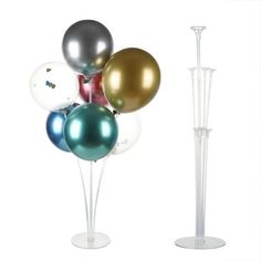 a bunch of balloons sitting on top of a white stand next to a tall pole